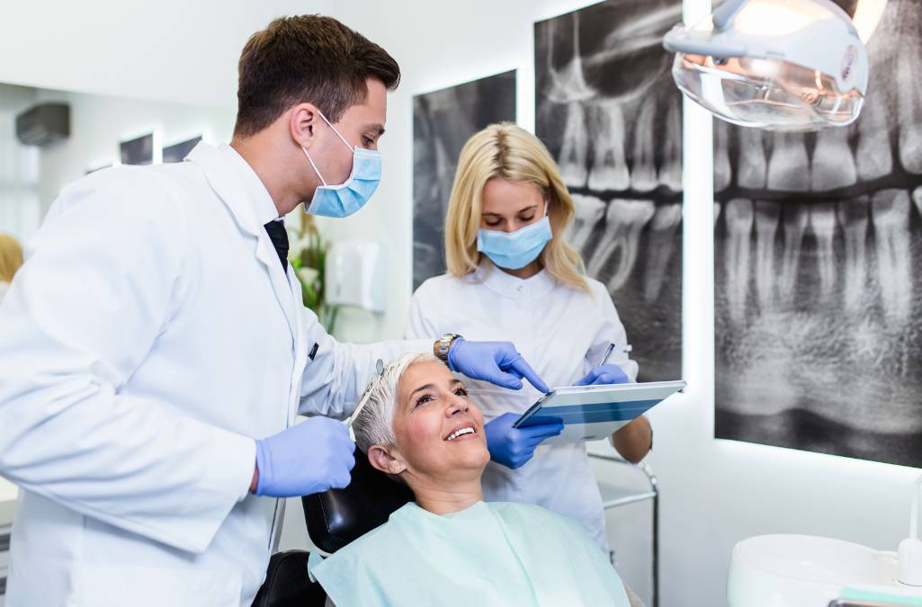 Woman in dentist chair with dentist and dental hygenist