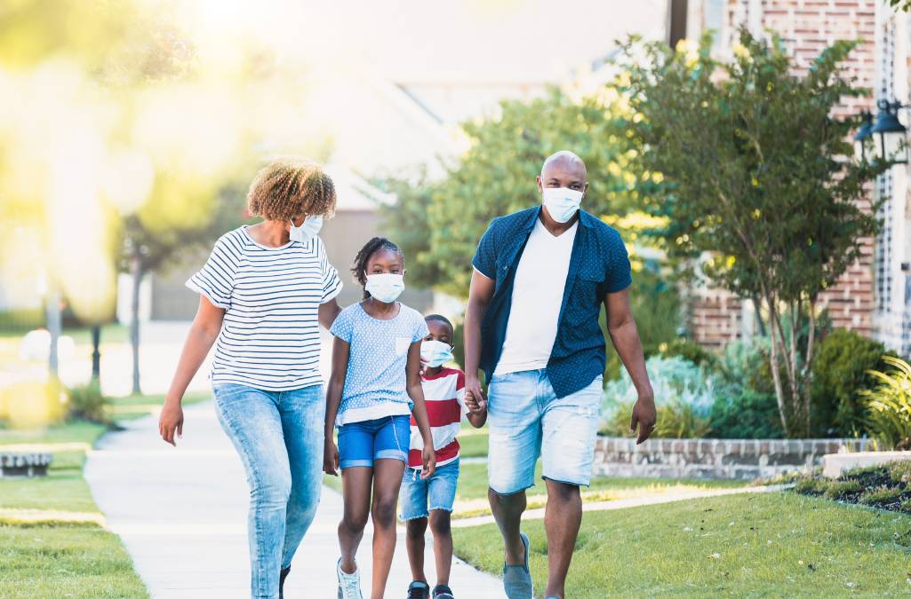 Family walking wearing covid masks