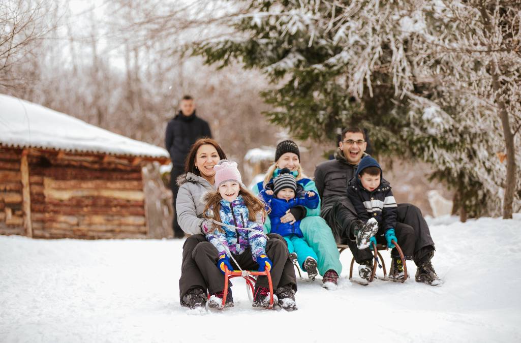 Family tobogganing in the snow