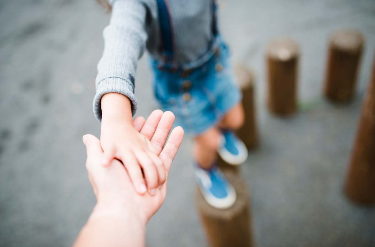 jeune fille espérant à travers les journaux tenant la main des parents